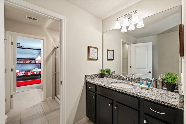 bathroom with a textured ceiling, vanity, a shower with shower door, tile patterned floors, and a chandelier