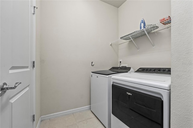 clothes washing area featuring light tile patterned floors and independent washer and dryer