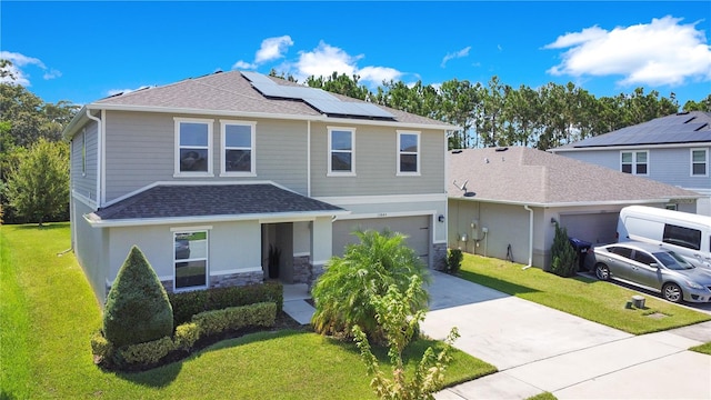 view of property with a garage, solar panels, and a front yard