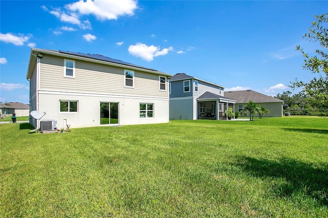 back of property featuring a yard and central AC