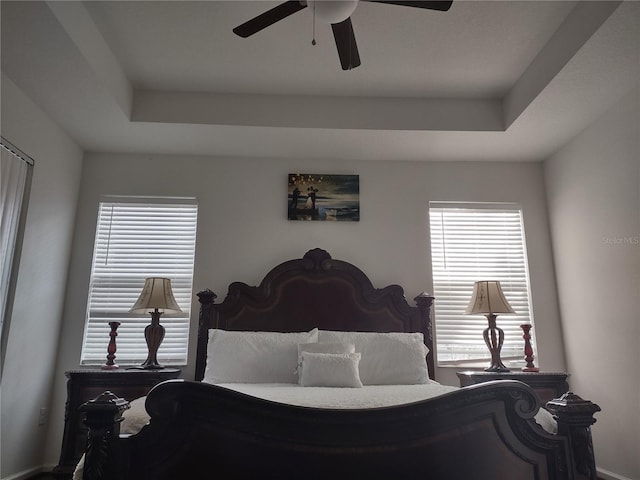 bedroom with a tray ceiling and ceiling fan