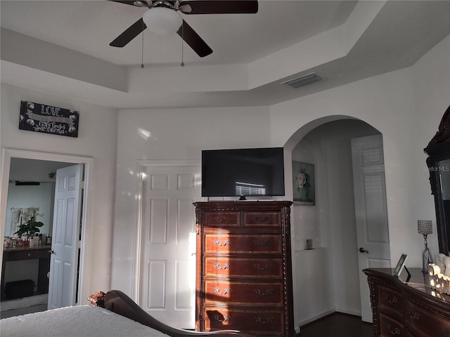 bedroom featuring ceiling fan and a raised ceiling