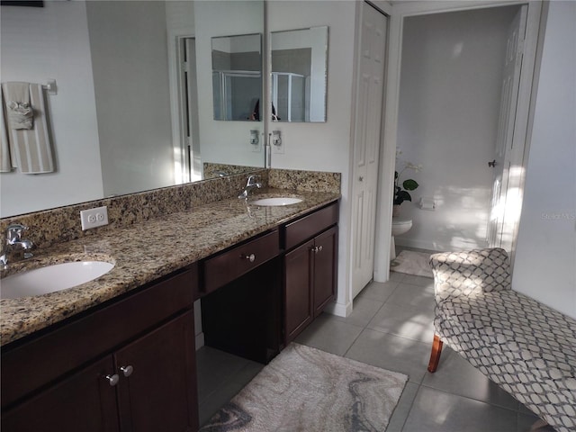 bathroom featuring vanity, toilet, tile patterned floors, and a shower with door