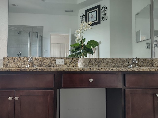 bathroom with vanity and a shower with shower door