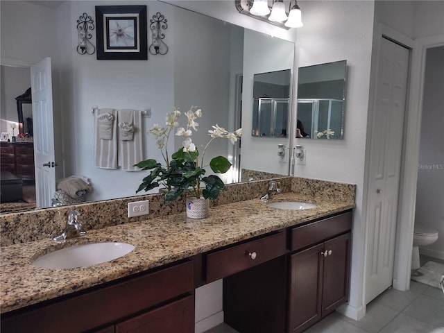 bathroom featuring vanity, toilet, tile patterned floors, and a shower with door