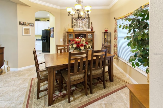 tiled dining space with an inviting chandelier and crown molding