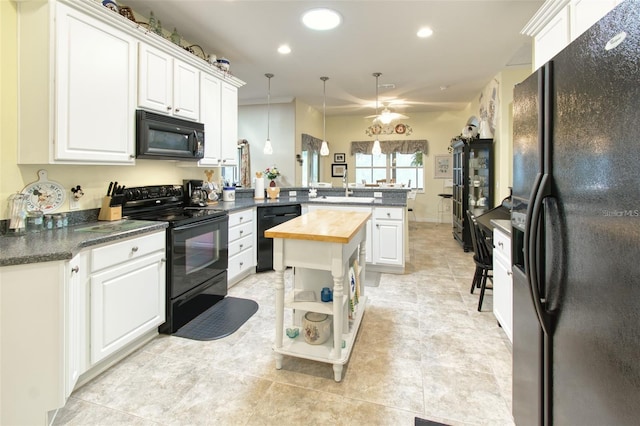 kitchen featuring butcher block countertops, light tile patterned floors, kitchen peninsula, pendant lighting, and black appliances