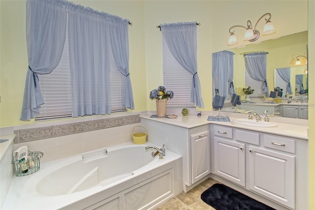 bathroom with tile patterned floors, a bathing tub, and vanity