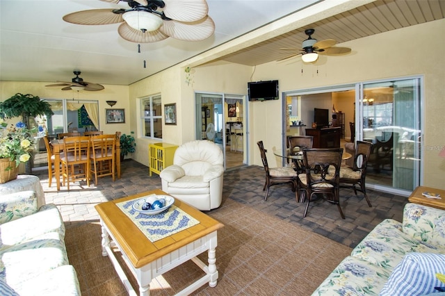 living room with ceiling fan and beamed ceiling