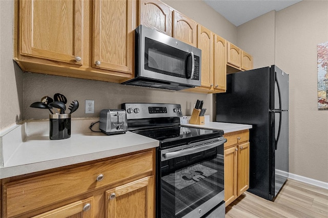 kitchen with stainless steel appliances and light hardwood / wood-style floors