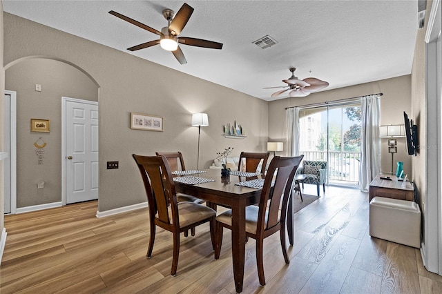 dining space featuring a textured ceiling, light hardwood / wood-style flooring, and ceiling fan