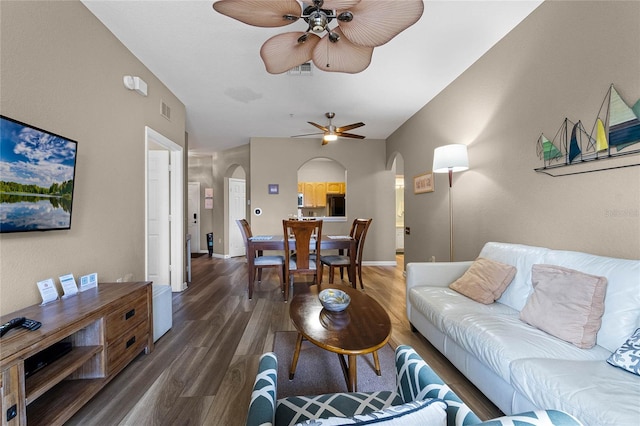 living room with dark wood-type flooring and ceiling fan