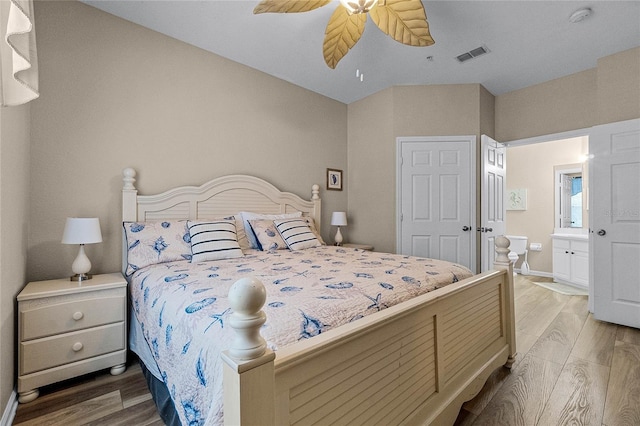 bedroom featuring light wood-type flooring, ceiling fan, and ensuite bathroom