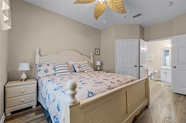 7671 Comrow St Unit 202, Kissimmee, FL 34747 - bedroom with light wood-style floors, ensuite bathroom, baseboards, and ceiling fan