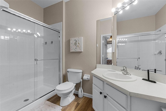 bathroom with vanity, toilet, hardwood / wood-style flooring, and walk in shower