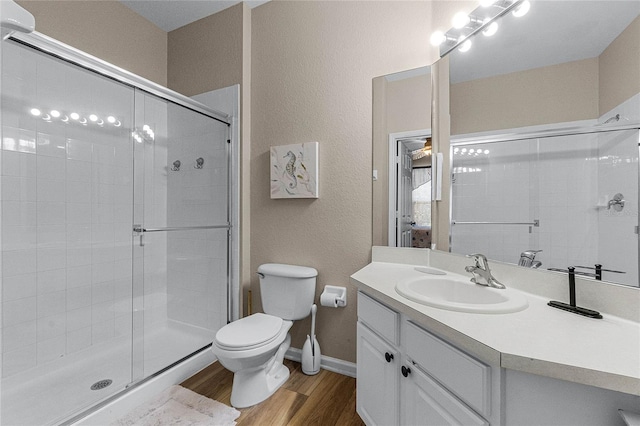 7671 Comrow St Unit 202, Kissimmee, FL 34747 - full bathroom featuring toilet, wood finished floors, a shower stall, vanity, and baseboards