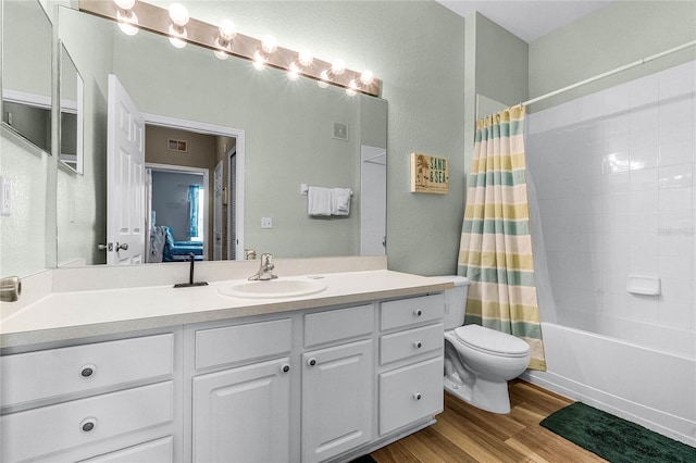 7671 Comrow St Unit 202, Kissimmee, FL 34747 - full bathroom with toilet, wood finished floors, shower / bath combination with curtain, vanity, and a textured wall