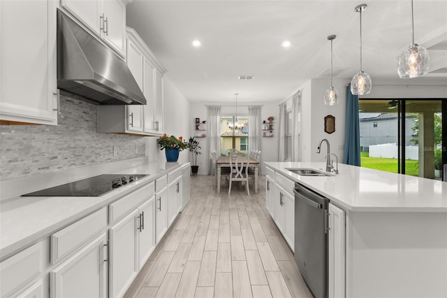 kitchen featuring dishwasher, black electric cooktop, a kitchen island with sink, and a healthy amount of sunlight