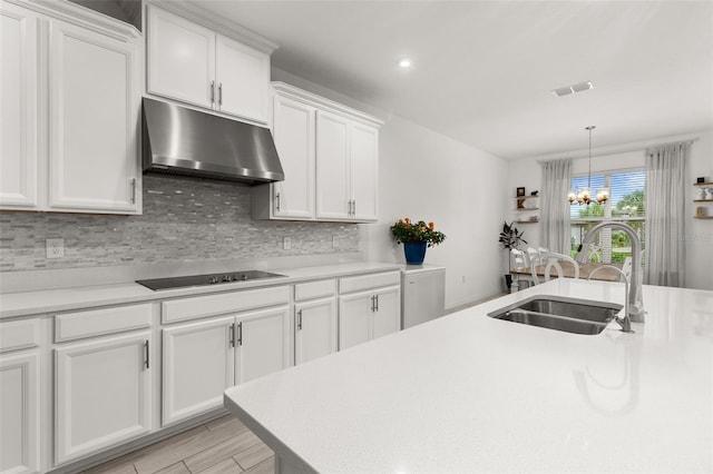 kitchen with white cabinetry, sink, light hardwood / wood-style flooring, a notable chandelier, and black electric cooktop