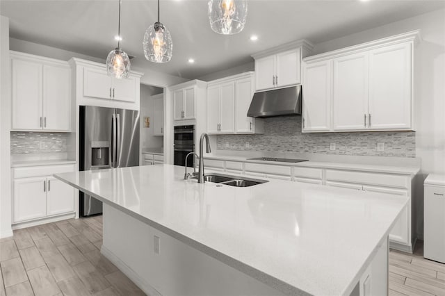 kitchen featuring appliances with stainless steel finishes, a center island with sink, white cabinetry, and sink