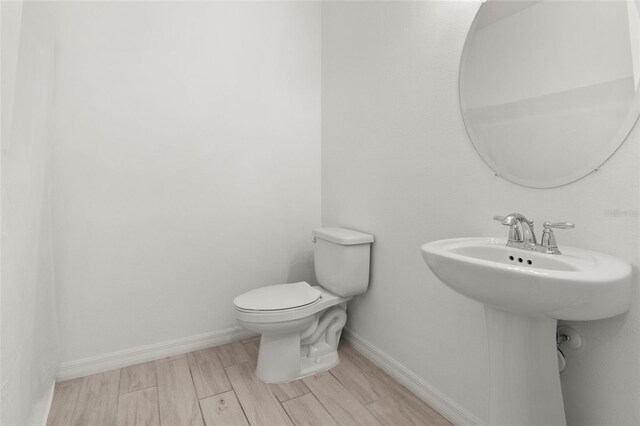 bathroom with wood-type flooring and toilet