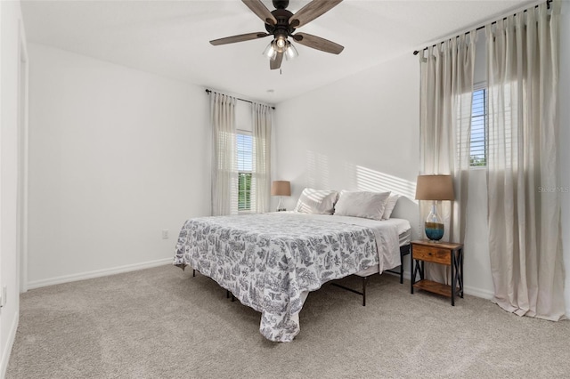 carpeted bedroom with multiple windows and ceiling fan