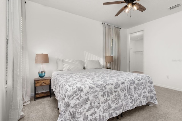 bedroom with carpet, ceiling fan, a spacious closet, and a closet