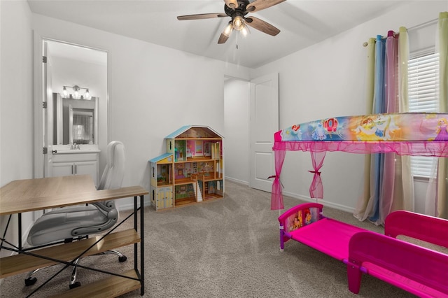 carpeted bedroom with ensuite bathroom, ceiling fan, sink, and multiple windows