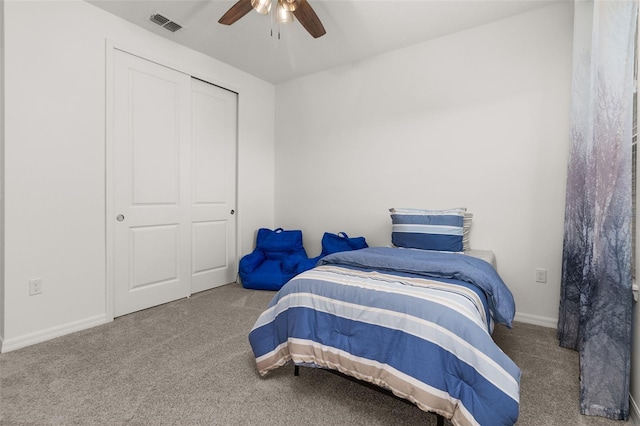 carpeted bedroom featuring ceiling fan and a closet