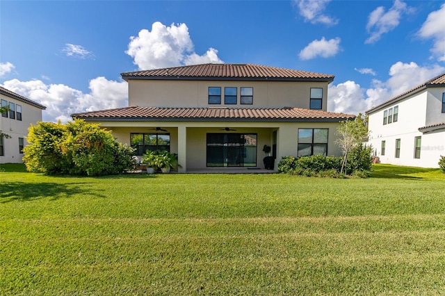 rear view of property with a yard and ceiling fan