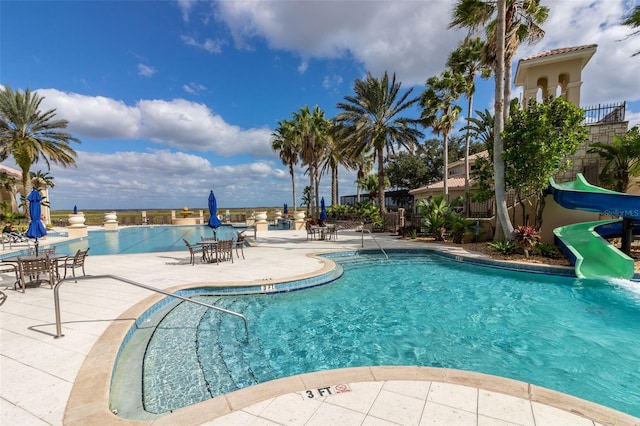 view of pool featuring a patio area and a water slide