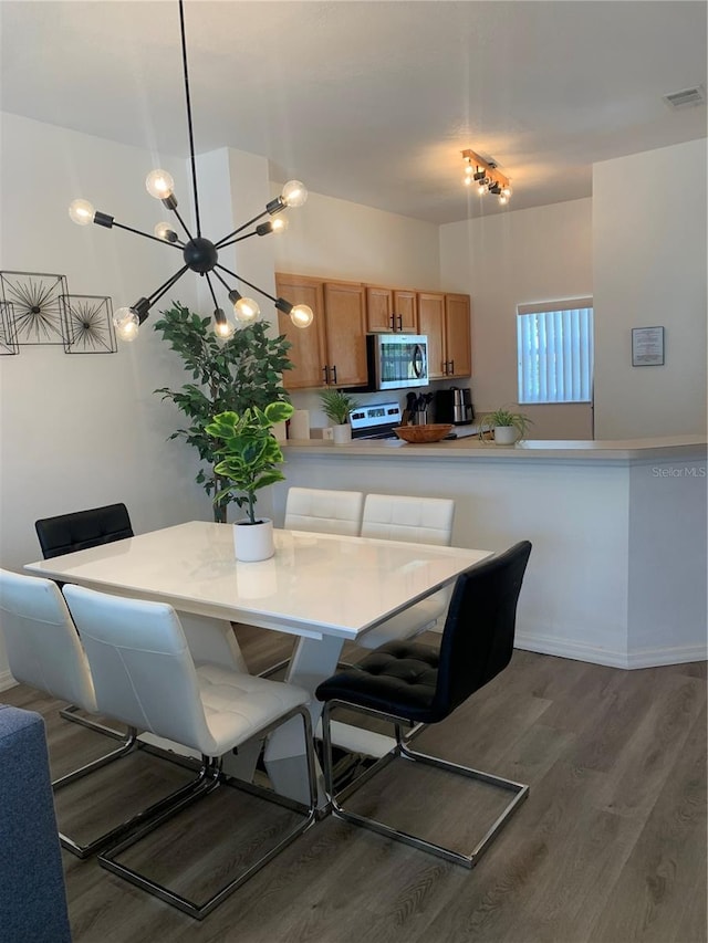 dining space with a notable chandelier and hardwood / wood-style flooring