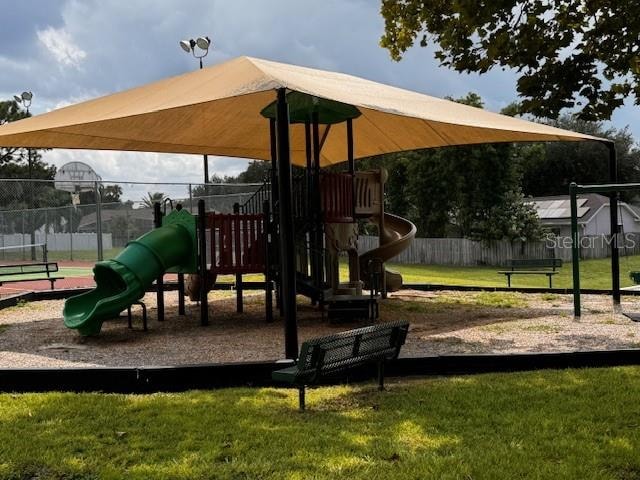 view of playground featuring a lawn and basketball court