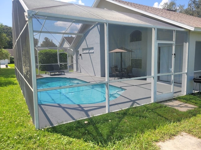 view of pool featuring a patio, a yard, and a lanai