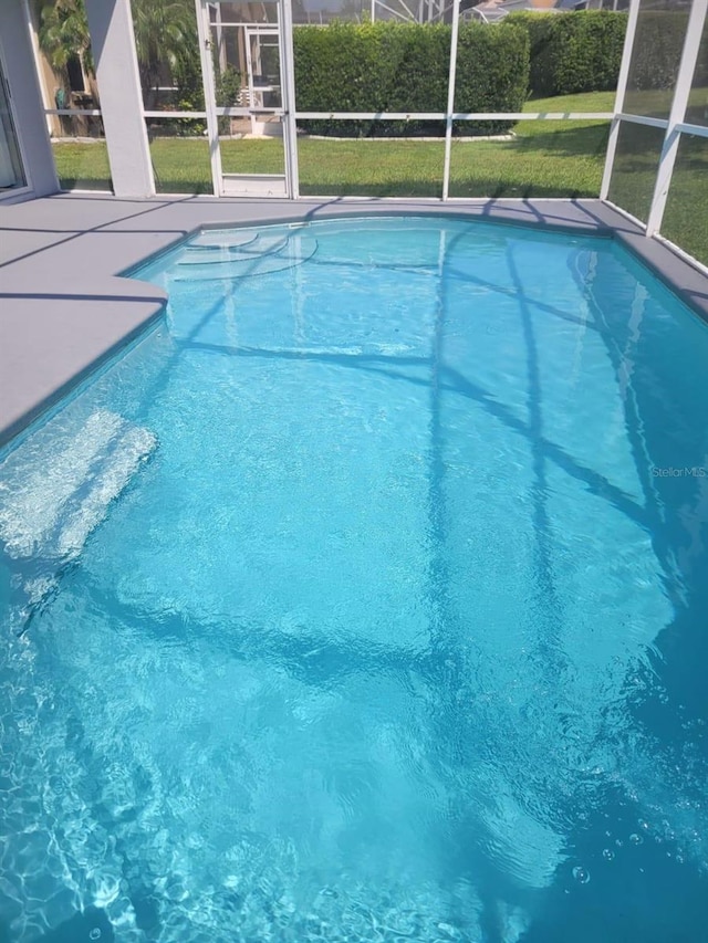 view of pool featuring a lanai and a lawn