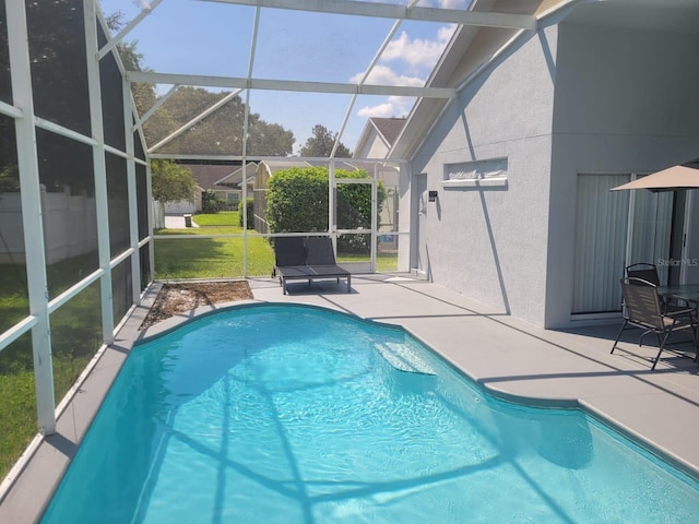 view of swimming pool featuring glass enclosure, a patio area, and a lawn