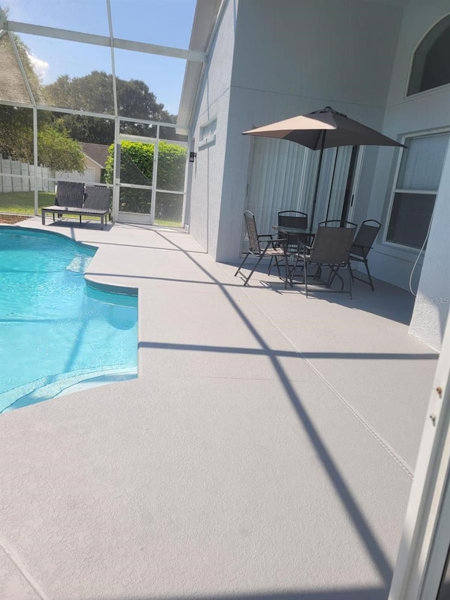 view of swimming pool featuring a patio and glass enclosure