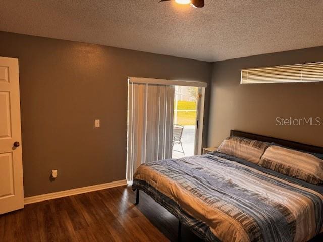 bedroom featuring a textured ceiling and dark wood-type flooring