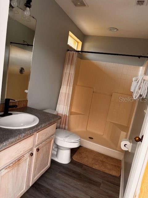 bathroom featuring vanity, hardwood / wood-style floors, toilet, and a shower with shower curtain