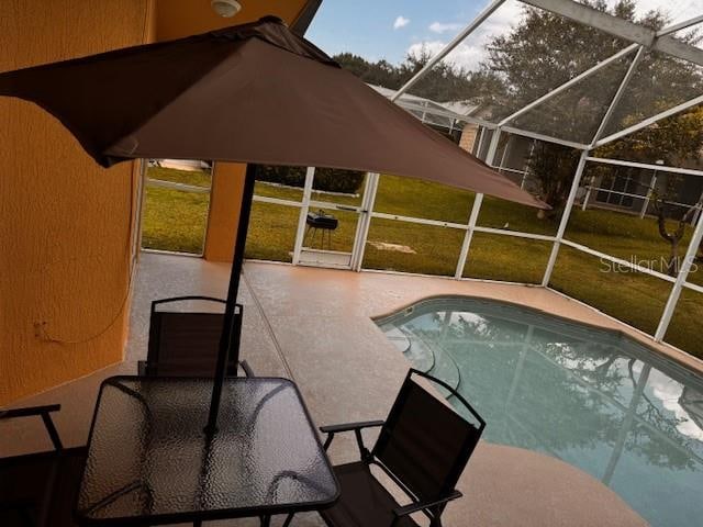 view of pool featuring glass enclosure and a patio