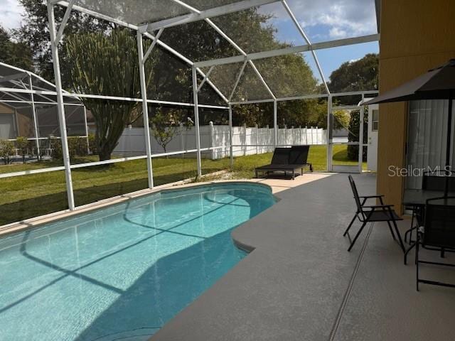 view of swimming pool with a patio, glass enclosure, and a yard