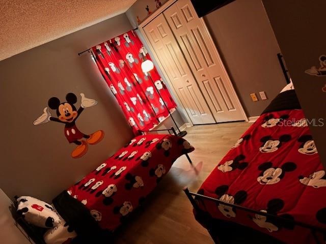 unfurnished bedroom featuring hardwood / wood-style flooring, a closet, and a textured ceiling