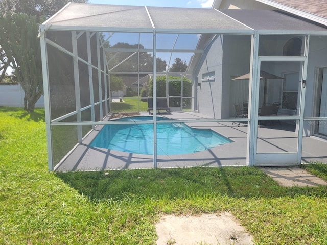 view of swimming pool with a patio, a lawn, and a lanai