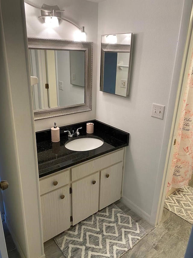 full bathroom with vanity and baseboards