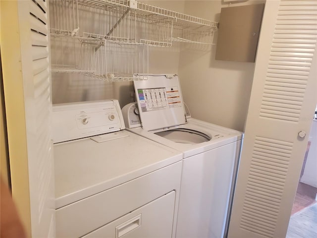 clothes washing area featuring hardwood / wood-style flooring and separate washer and dryer