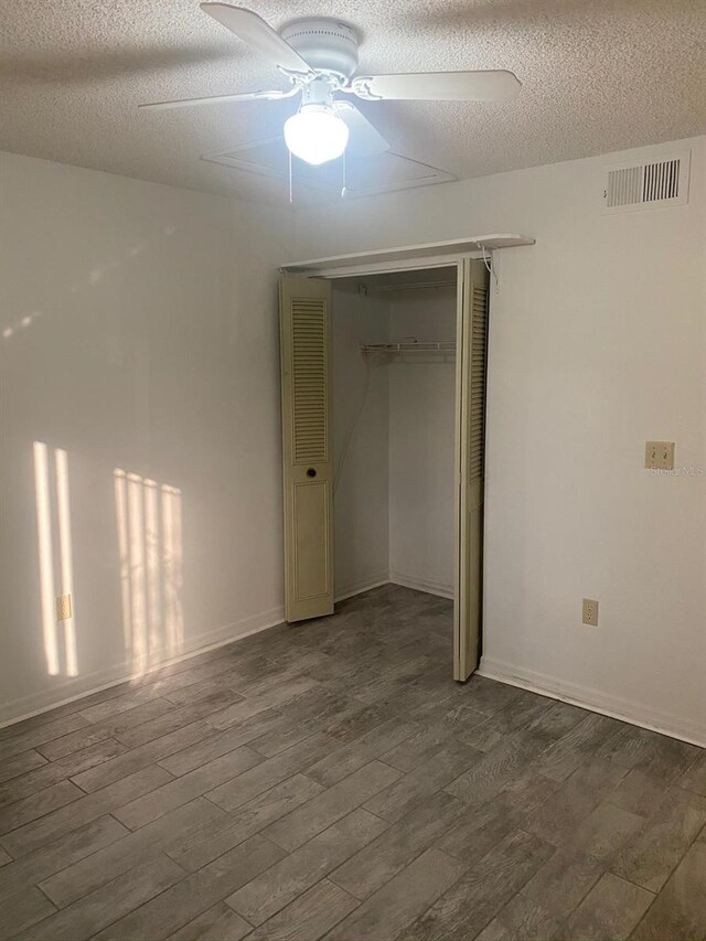 2647 Surrey Ct Unit 2647, Kissimmee, FL 34741 - unfurnished bedroom with a closet, a textured ceiling, visible vents, and wood finished floors