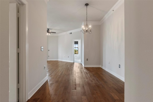 spare room featuring visible vents, baseboards, dark wood-style flooring, crown molding, and ceiling fan with notable chandelier