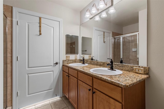 bathroom featuring a sink, double vanity, a stall shower, and tile patterned floors