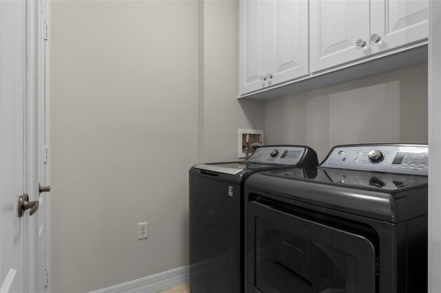 clothes washing area with cabinet space, baseboards, and washer and clothes dryer