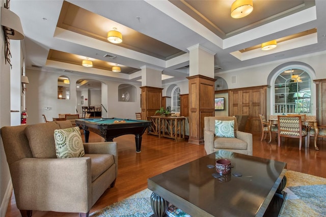 rec room featuring arched walkways, crown molding, a raised ceiling, and wood finished floors